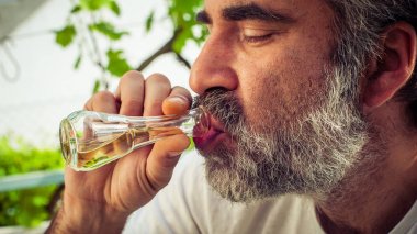 Sakallı adam konyak içmeye