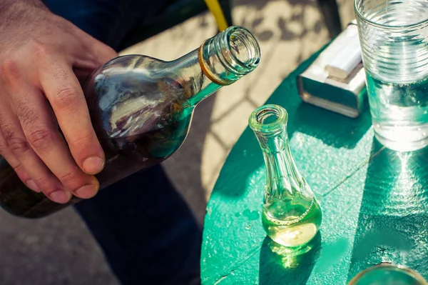 Verser le brandy domestique de la bouteille dans le verre — Photo