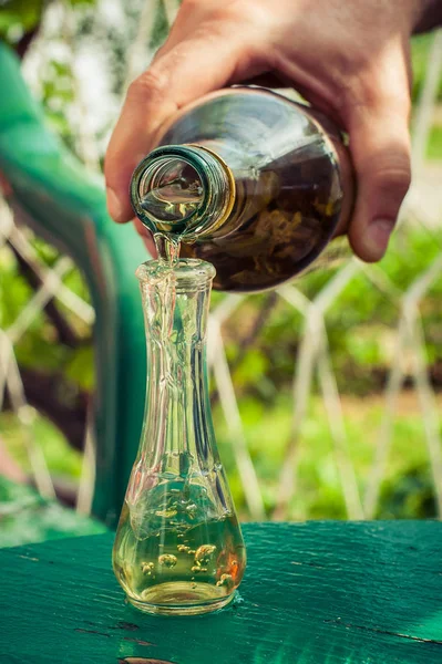 Наливание коньяка из бутылки в стекло — стоковое фото