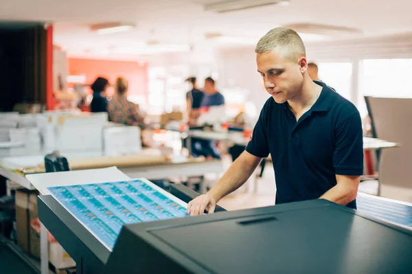 Young man working in printing factory — Stock Photo, Image
