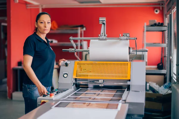 Jovem mulher trabalhando na fábrica de impressão — Fotografia de Stock