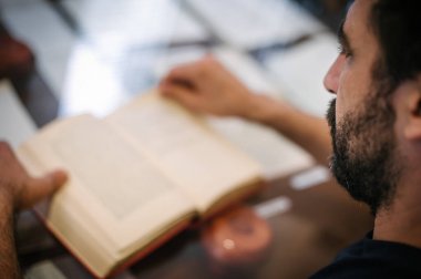 Genç adam kitap okuma masaya öğrenme