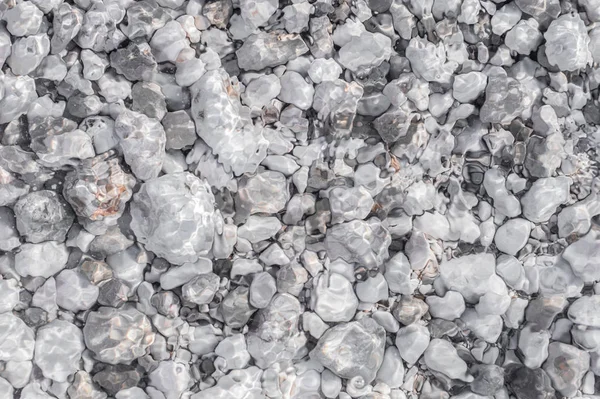 Guijarros de mar en la playa bajo una capa de agua transparente — Foto de Stock