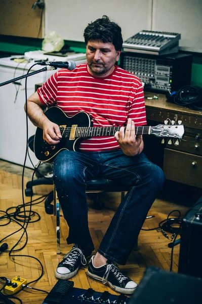 Dans les coulisses. Guitariste pratique jouer de la guitare dans la musique désordonnée s — Photo