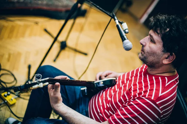 Dans les coulisses. Guitariste pratique jouer de la guitare dans la musique désordonnée s — Photo