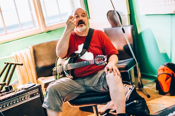 Dans les coulisses. Guitariste pratique jouer de la guitare dans la musique désordonnée s — Photo