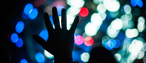 Silhouette of raised hands and arms at concert festival party