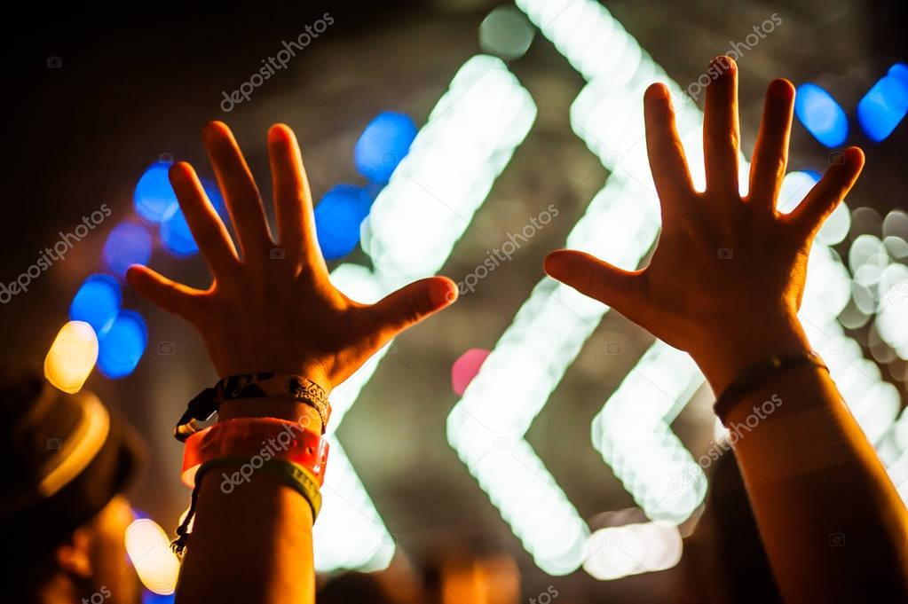 Silhouette of raised hands and arms at concert festival party