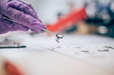 Cımbız ile teknisyen cep telefonu parçaları se sırasında taşır.