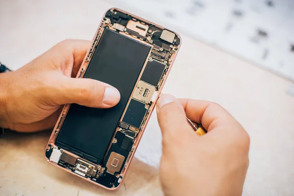 Technician repairs and inserts sim memory card on mobile phone