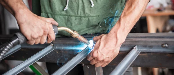 Trabajador industrial soldando la estructura de acero en el taller — Foto de Stock