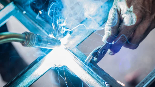 Industrial worker welding the steel structure in the workshop — Stock Photo, Image