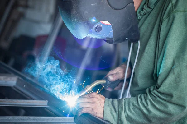 Soldador industrial trabalhando um metal de soldagem com máscara protetora — Fotografia de Stock