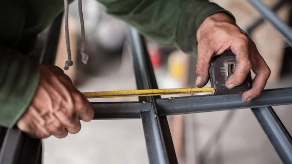 Trabajador midiendo acero con cinta métrica —  Fotos de Stock