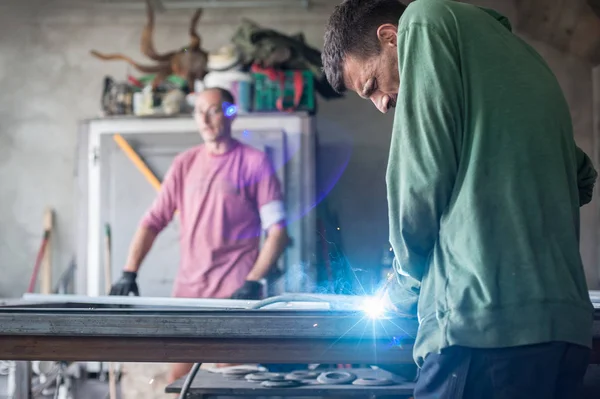 Промисловий робітник зварює сталеву конструкцію в майстерні — стокове фото