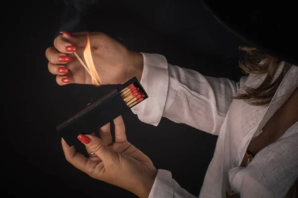 Женские руки зажигают большие спички для сигары или камина — стоковое фото