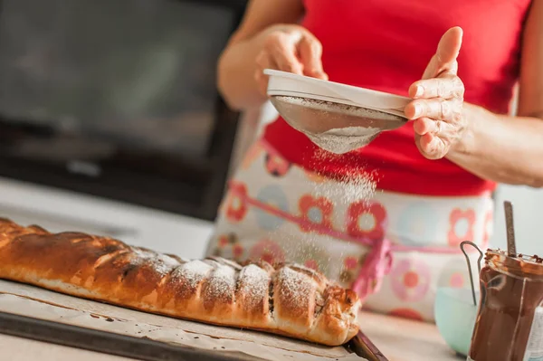 Kadın Şef üstünde belgili tanımlık tepe şekerli tatlı pasta bitirme