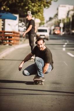 İki kaykay kaykay yamaç şehirdeki sokak binmek