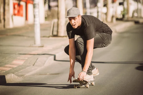 Skateboarder cavalcare un pendio skateboard attraverso la strada della città — Foto Stock