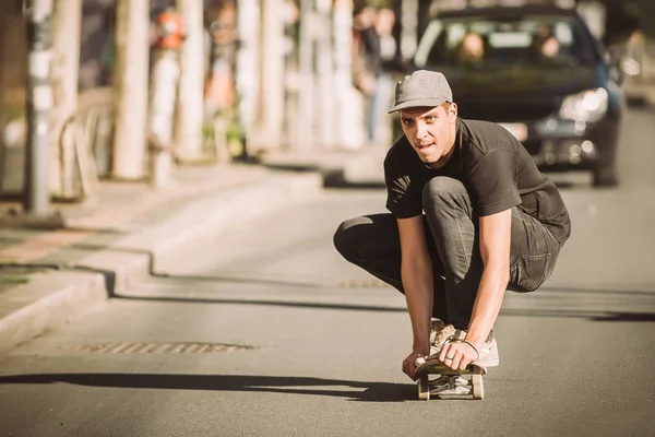 Skateboardista jezdit na skateboardu svahu přes město ulice — Stock fotografie