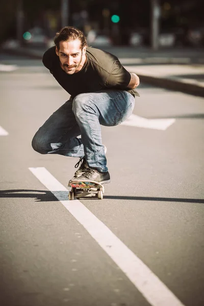 Skateboardista jezdit na skateboardu svahu přes město ulice — Stock fotografie