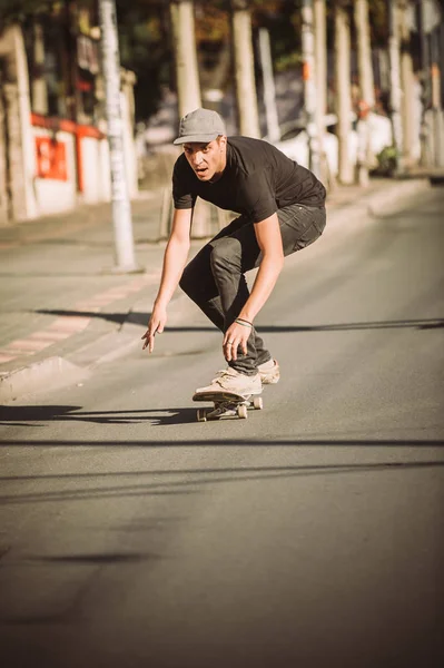 Skateboarder cavalcare un pendio skateboard attraverso la strada della città — Foto Stock