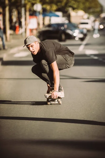 Skateboarder cavalcare un pendio skateboard attraverso la strada della città — Foto Stock