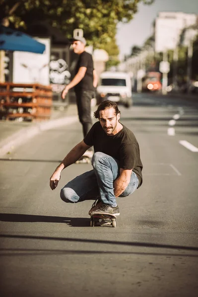 İki kaykay kaykay yamaç şehirdeki sokak binmek