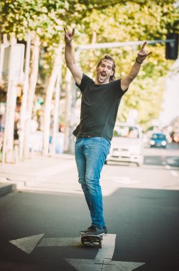 Mutlu ve komik kaykaycı şehir st aracılığıyla kaykay binmek