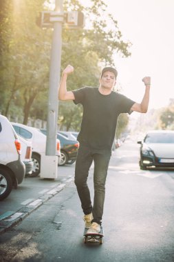 Mutlu ve komik kaykaycı şehir st aracılığıyla kaykay binmek