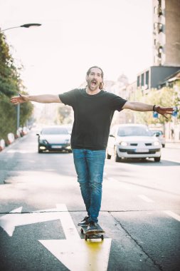 Mutlu ve komik kaykaycı şehir st aracılığıyla kaykay binmek