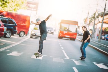 İki kaykay kaykay yamaç şehir sokaklarda sürme
