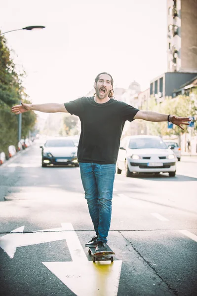 Mutlu ve komik kaykaycı şehir st aracılığıyla kaykay binmek