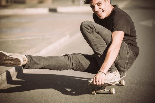 Счастливый и смешной скейтбордист катается на скейтборде по городу — стоковое фото