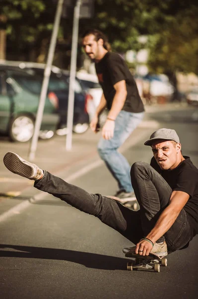 Dos patinadores felices y divertidos montan monopatín en la ciudad stree —  Fotos de Stock