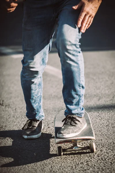 Skateboarder benen paardrijden skateboard op straat — Stockfoto
