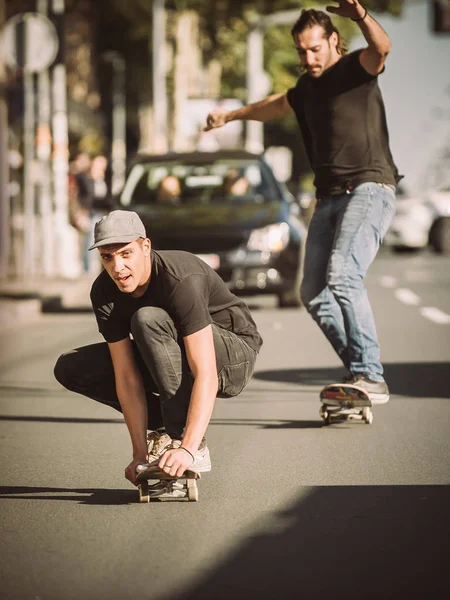 Two skateboarders riding skateboard slope on the city streets