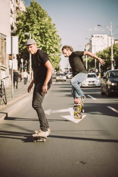 Два скейтбордиста катаются на скейтборде по улицам города — стоковое фото