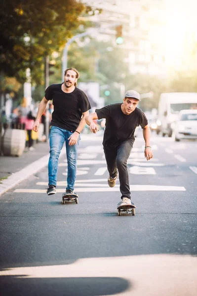 Dois skatistas andando de skate nas ruas da cidade — Fotografia de Stock