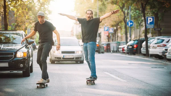 Два скейтбордисти катаються на схилі скейтборду на вулицях міста — стокове фото