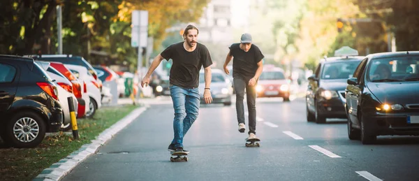 Два скейтбордисти катаються на схилі скейтборду на вулицях міста — стокове фото