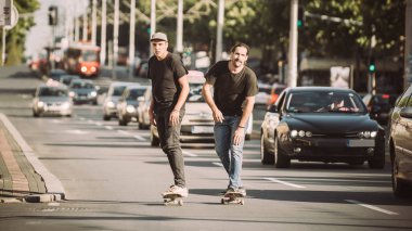 İki kaykay kaykay yamaç şehir sokaklarda sürme