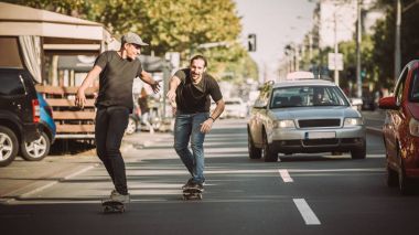 İki kaykay kaykay yamaç şehir sokaklarda sürme