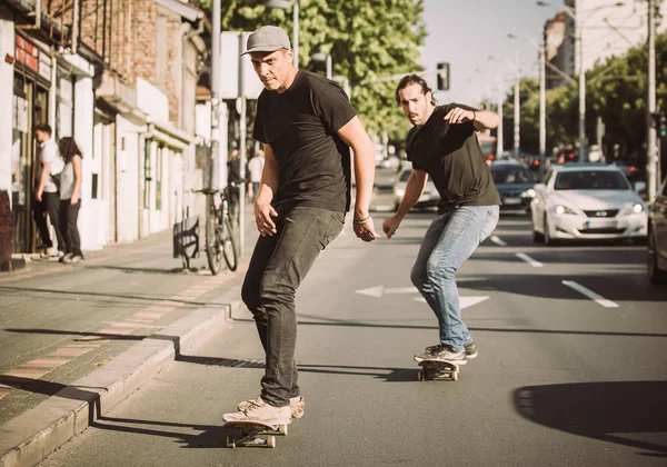 İki kaykay kaykay yamaç şehir sokaklarda sürme