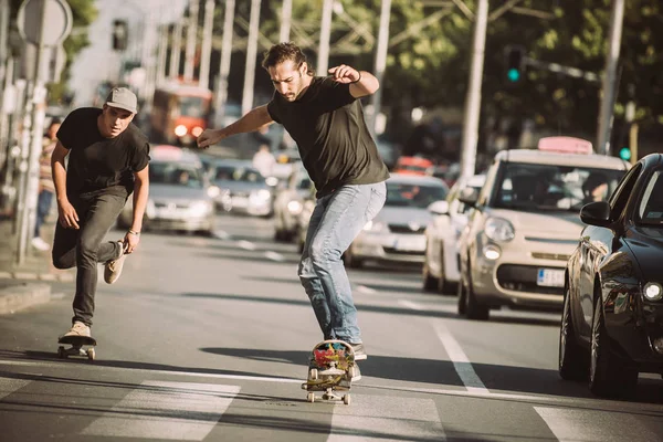 İki kaykay kaykay yamaç şehir sokaklarda sürme