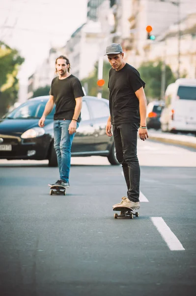 İki kaykay kaykay yamaç şehir sokaklarda sürme