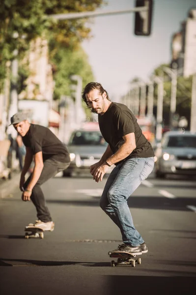 スケート ボードの斜面に乗って街の通り 2 つのスケートボーダー — ストック写真