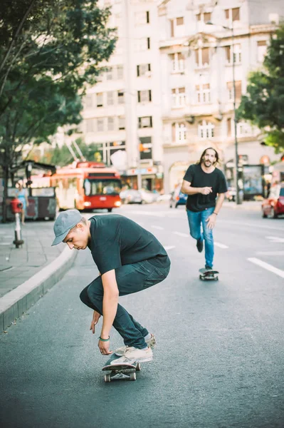 Два скейтбордиста катаются на скейтборде по улицам города — стоковое фото
