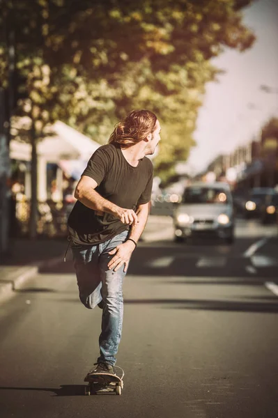 Pro skateboardista jezdit na skateboardu na hlavní silnici ulice prostřednictvím — Stock fotografie