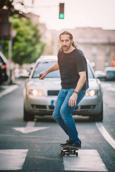 Şehir yolda araba önünde Pro kaykay binici